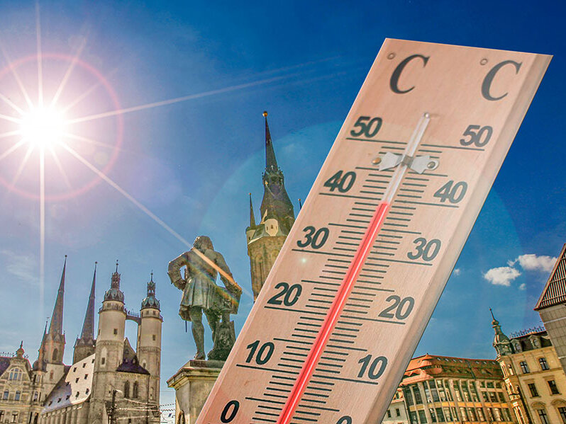 Holzthermometer zeigt fast 40 Grad an, im Hintergrund der Marktplatz von Halle