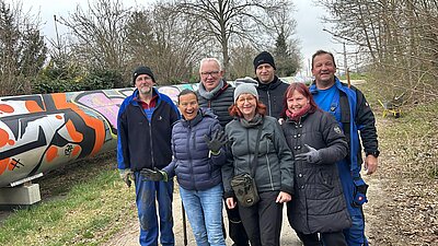 Foto zeigt eine Gruppe bestehend aus sieben Beteiligten der Initiative. Im Hintergrund ist ein Heizrohr zu sehen.