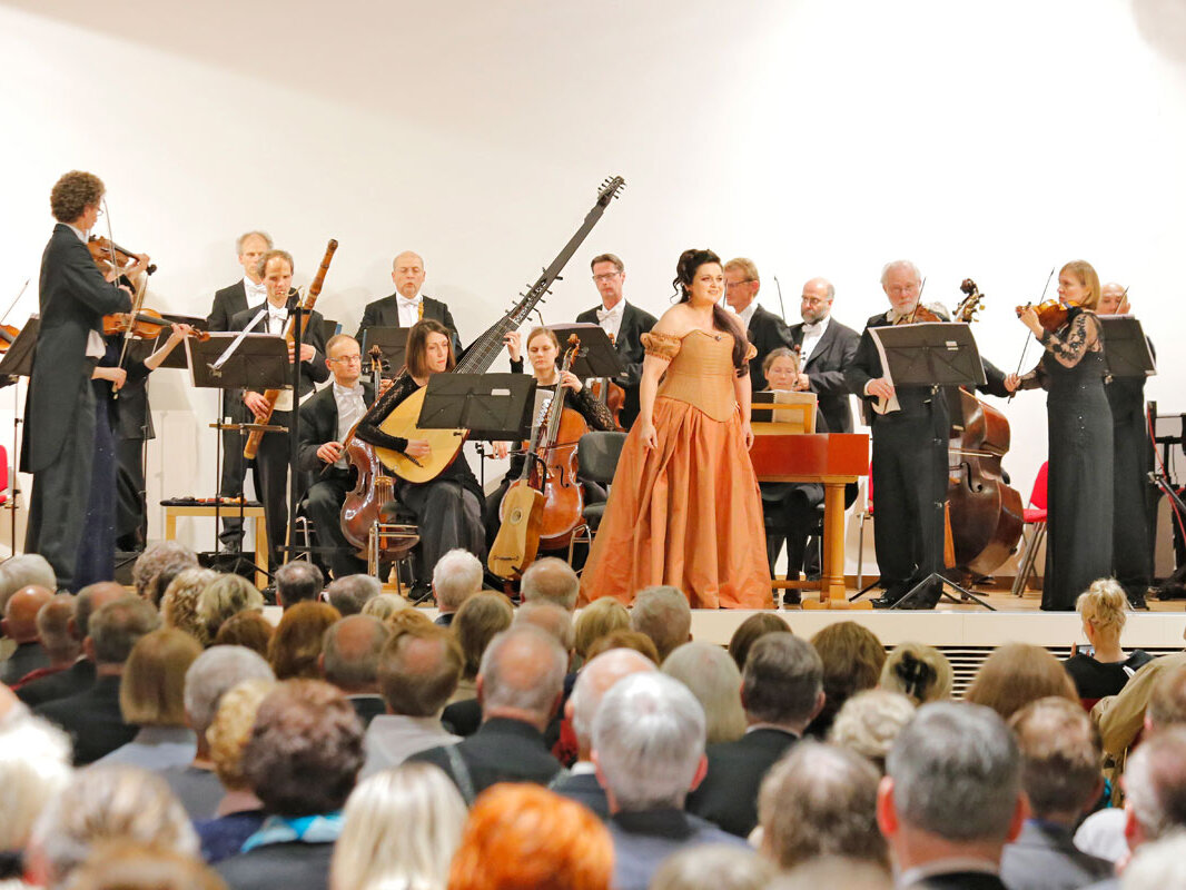 Musiker und Musikerinnen mit teilweise historischen Instrumenten, im Vordergrund Kammersängerin Romelia Lichtenstein 