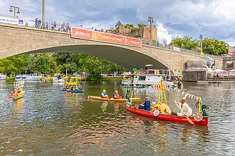 bunt geschmückte Boote an der Brücke in Kröllwitz