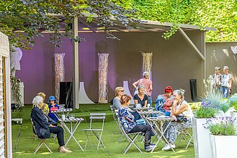 Tische und Stühle, Blick zur überdachten Bühne