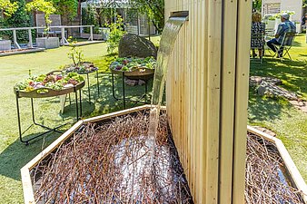 kleiner Wasserfall aus einer Holzwand