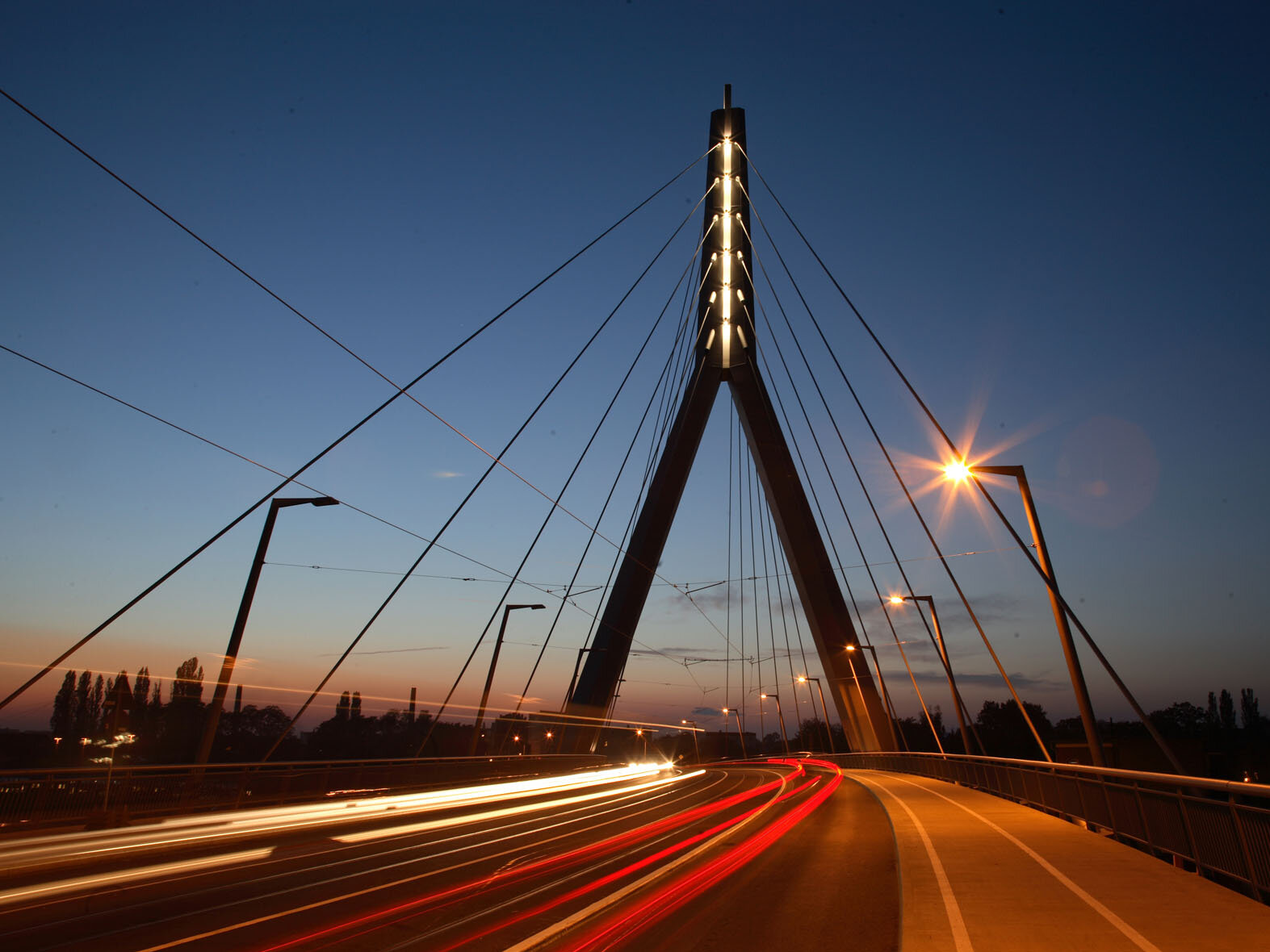 Berliner Brücke im Dunkeln beleuchtet mit Straße, Radfahrstreifen und Straßenbahnkörper