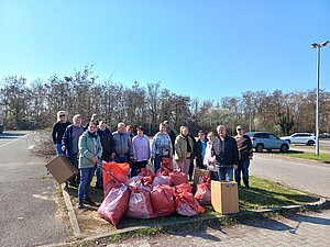 Ein Gruppenbild mit Personen, vor ihnen stehen befüllte Müllsäcke.