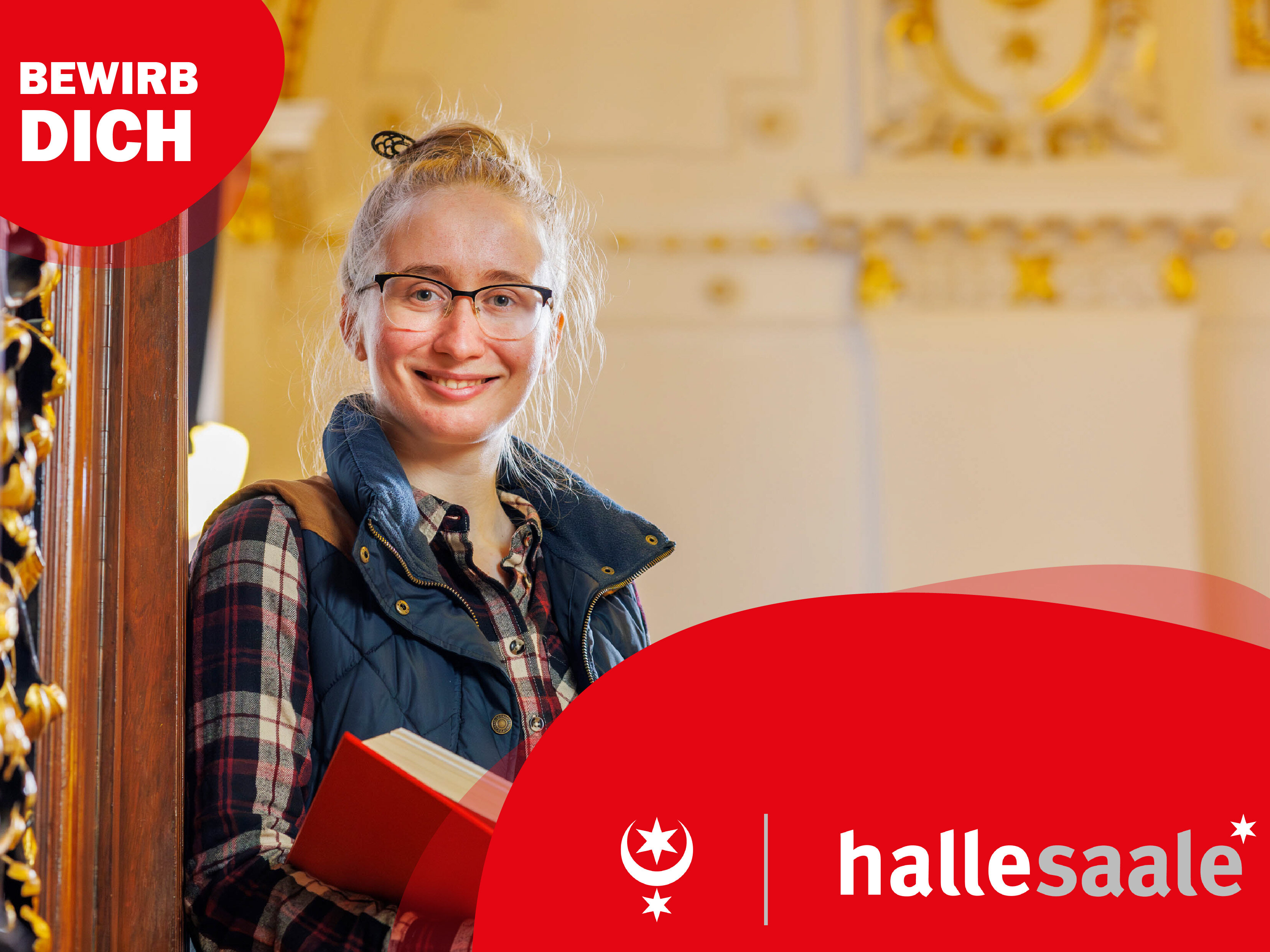 Elisa Katzer, Auszubildende zur Verwaltungsfachangestellten bei der Stadt Halle (Saale), steht im Treppenaufgang mit einem Buch in der Hand