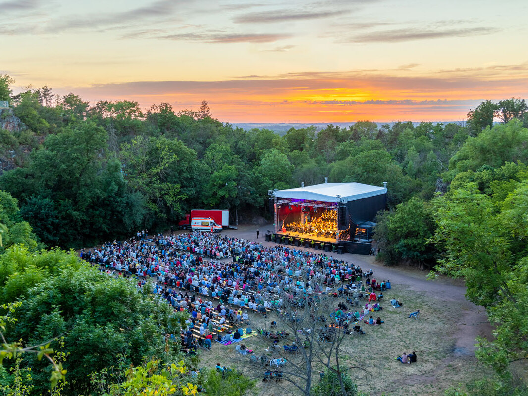 Blick von oben in die Galgenbergschlucht auf Bühne und Publikum bei Sonnenuntergang